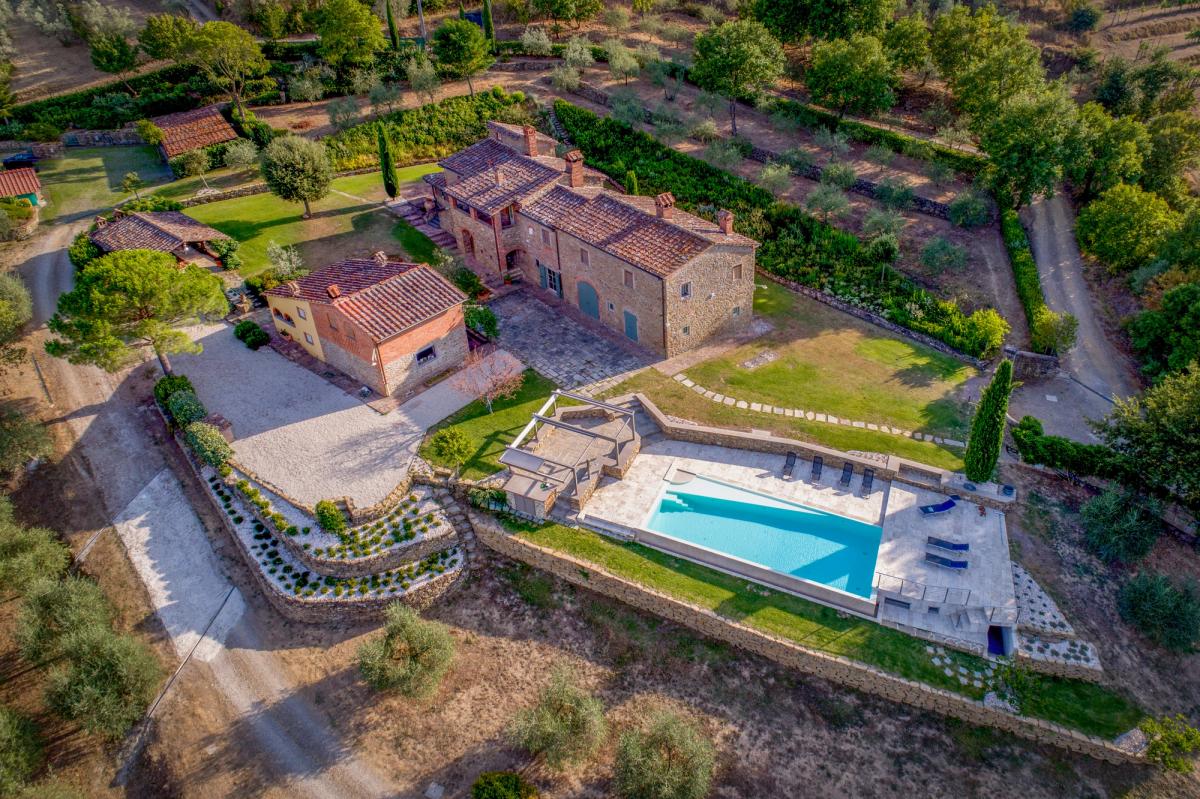 Vista aérea de edificios rurales, jardín y piscina